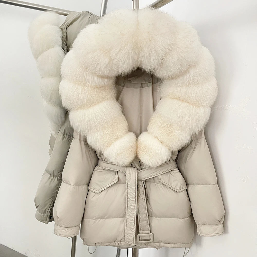 Beige puffer jacket with large white fur collar on a rack