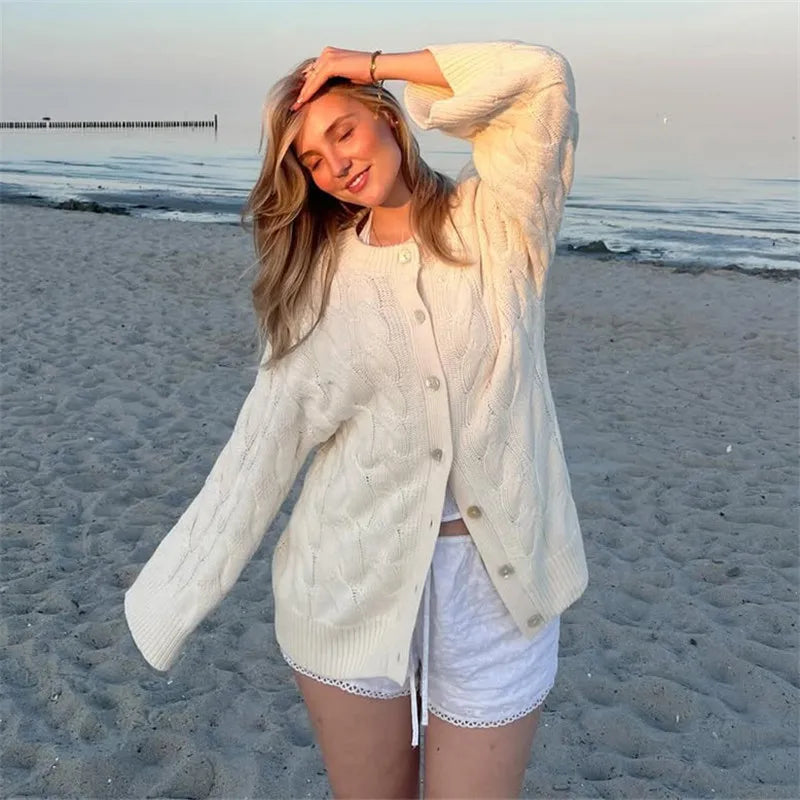 Woman in a white cardigan and shorts on a beach