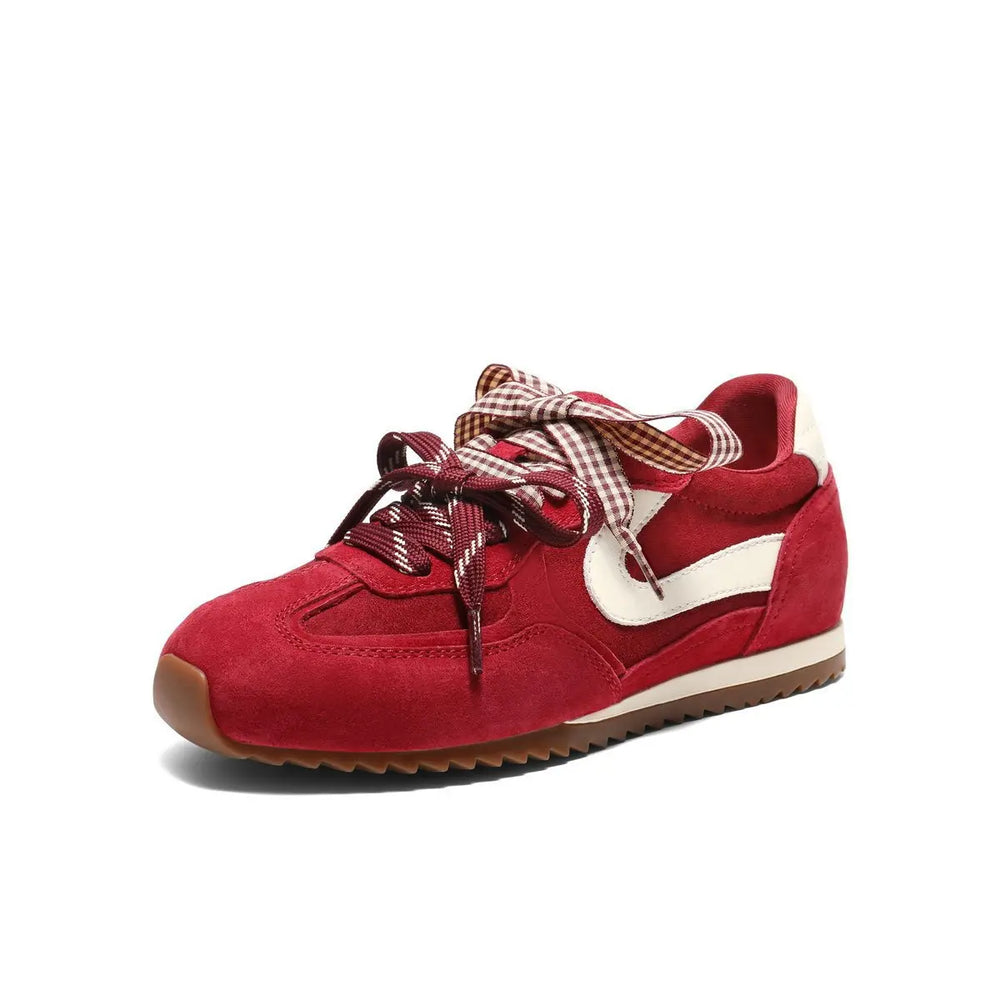 Side profile of a red suede sneaker with white accent and brown sole.