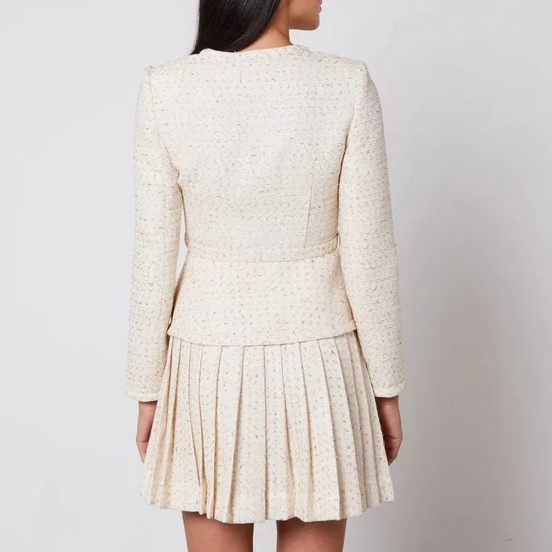 Woman wearing a cream-colored dress with a textured pattern