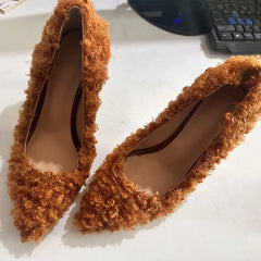 Pair of textured pointed toe stiletto heels on a surface