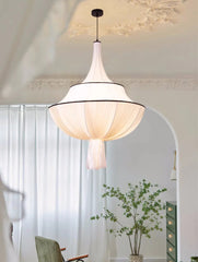 Modern pendant light fixture in a room with white walls and a plant.