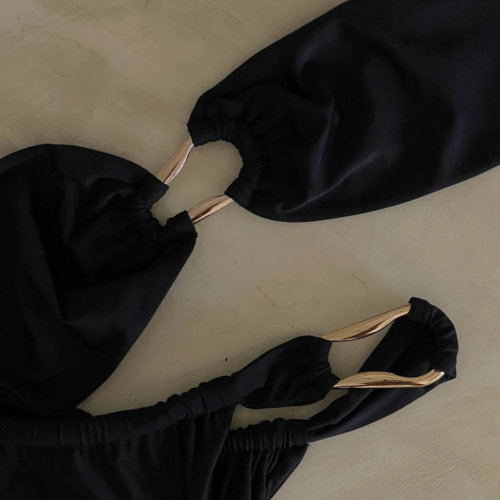Close-up view of the black bandeau bikini top and bottom showing the gold ring detail.