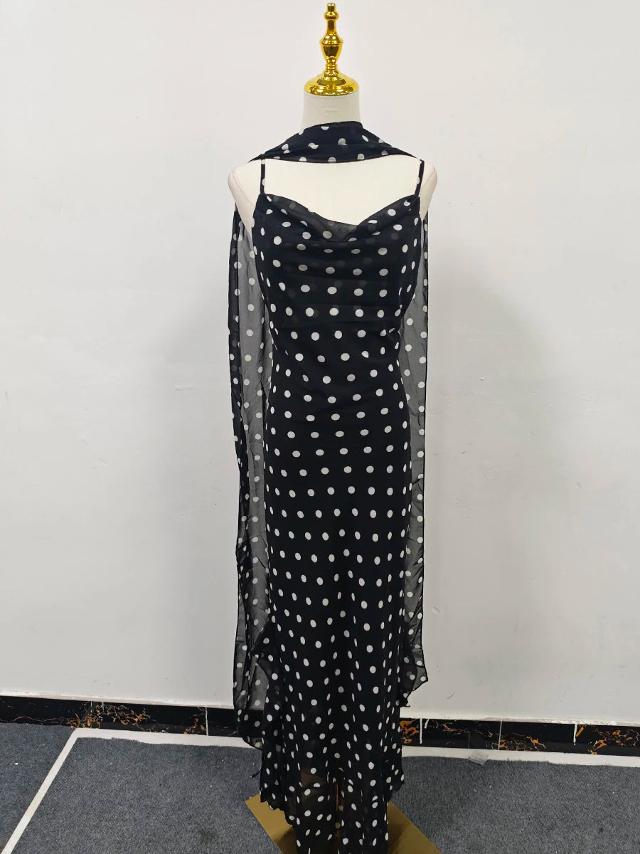 Black dress with white polka dots on a mannequin against a white background
