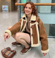 Woman wearing a brown shearling coat in an indoor setting