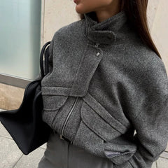 Person wearing a gray textured coat with a black bag.