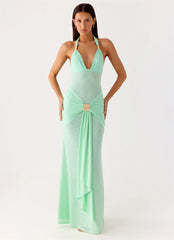Woman wearing a mint green evening gown on a white background