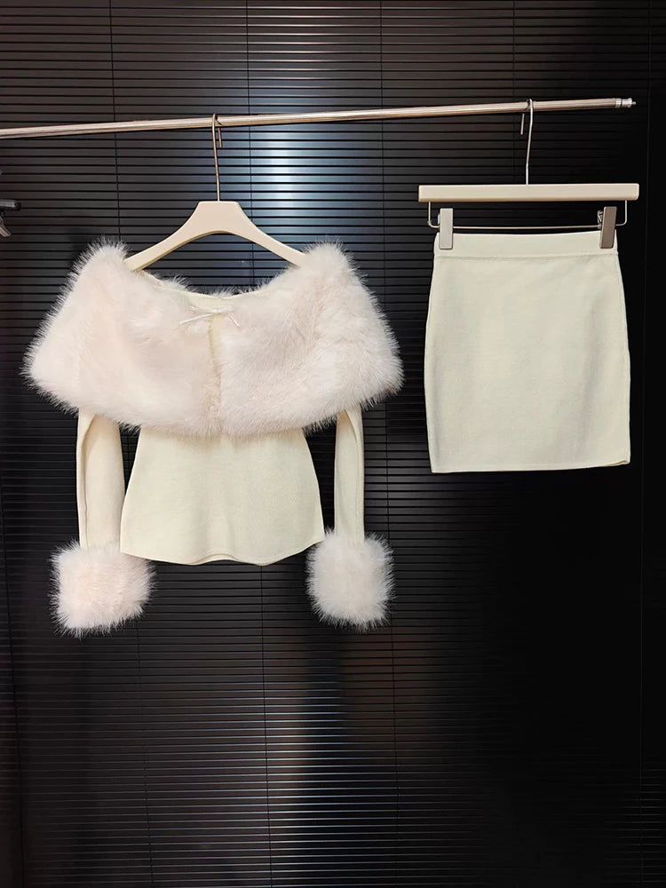 White outfit with fur accents on a hanger against a dark background