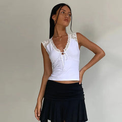 Woman wearing a white lace-trimmed top and black skirt against a plain background