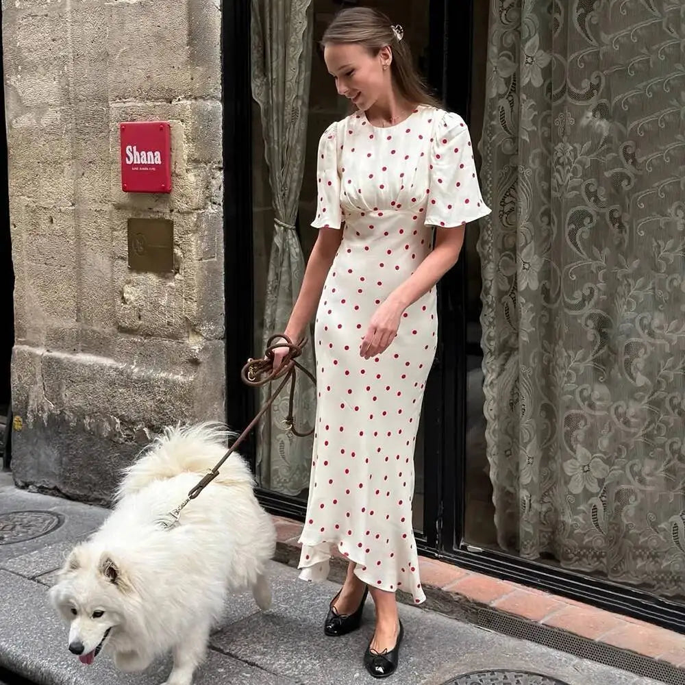 Woman walking a dog in a polka dot midi dress