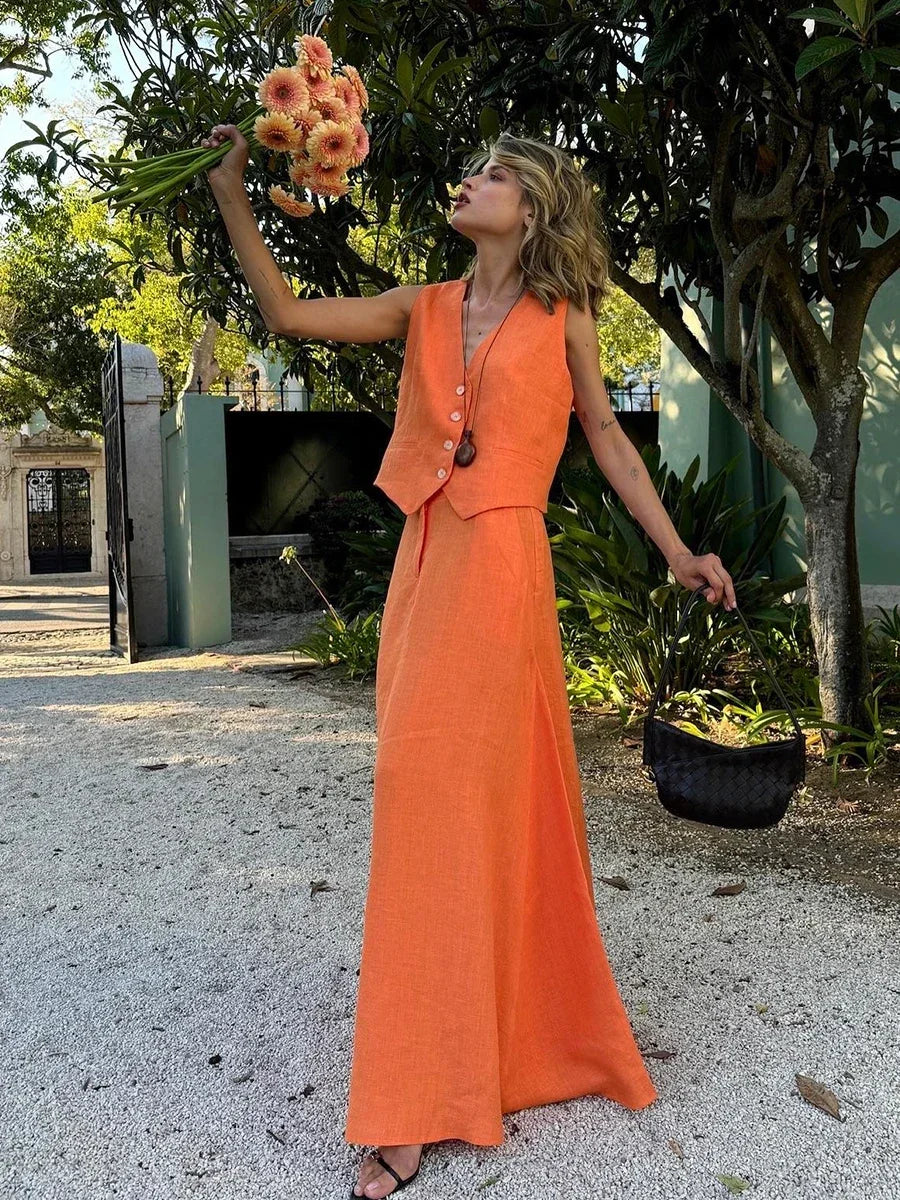 Woman in an orange dress holding flowers outdoors