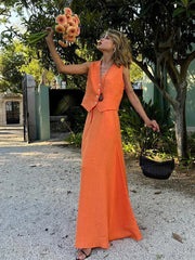 Woman in an orange dress holding flowers outdoors
