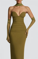 Woman wearing a green dress with sheer sleeves on a white background
