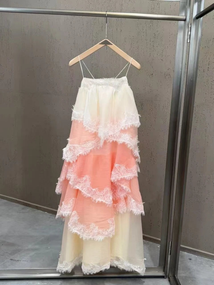 Layered dress with ruffled lace details on a hanger against a neutral background