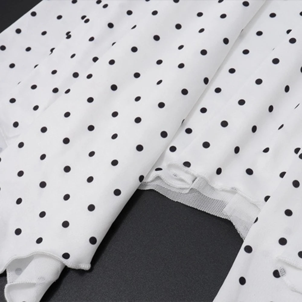 White fabric with black polka dots on a dark surface