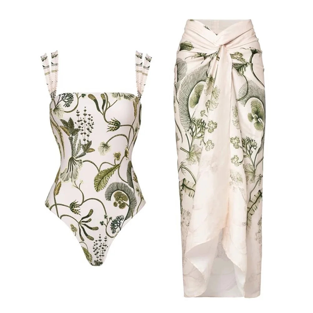 White one-piece swimsuit with green botanical print and matching botanical print sarong.