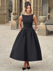 Woman wearing a black dress standing in front of classical architecture.