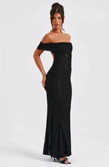 Woman wearing a black off-shoulder lace dress on a white background