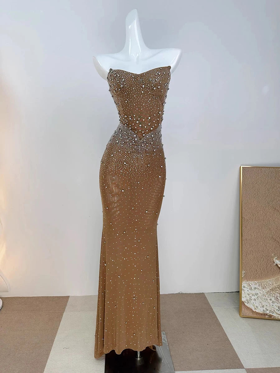 Gold beaded evening gown on a mannequin against a white background