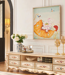 Decorative interior setting with a floral painting, table, and decor items.