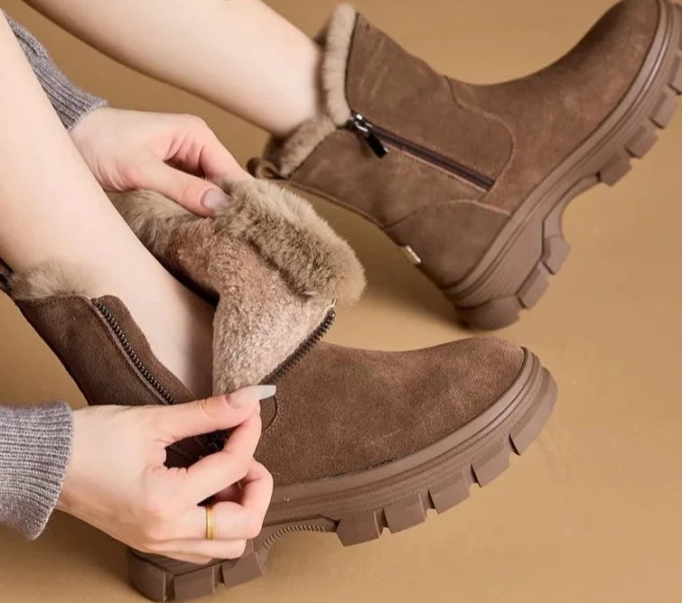 A pair of stylish suede leather snow boots with a warm plush lining and convenient side zippers.