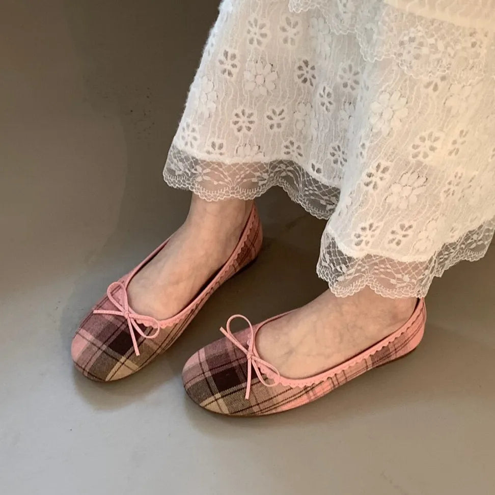 Multiple pairs of checked ballet flats arranged on a floor