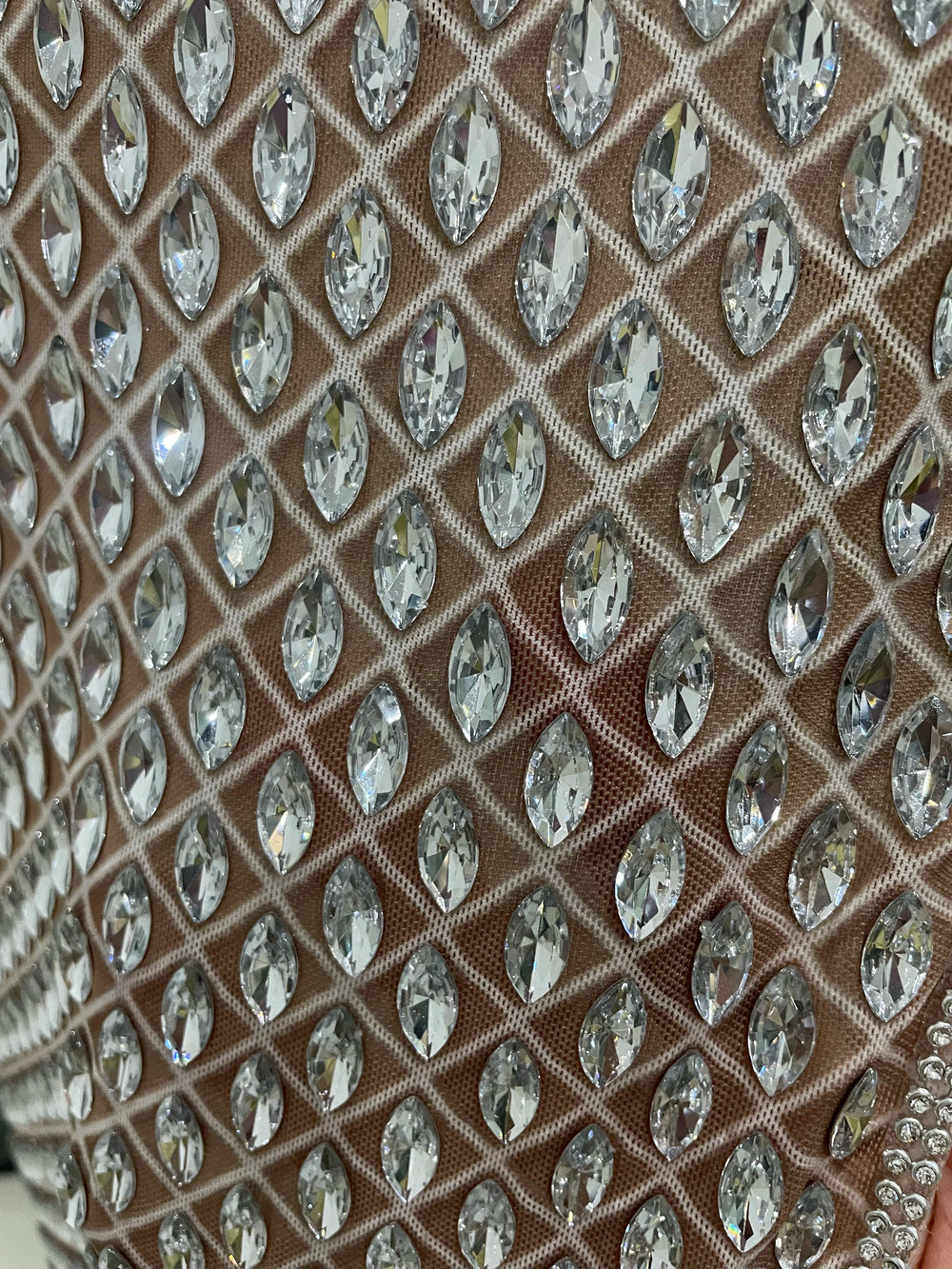 Close-up of a fabric with crystal-like embellishments on a brown background