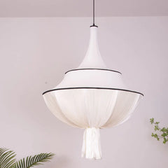 Close-up of a French pendant light, showcasing the delicate texture of the hand-stitched linen shade. A