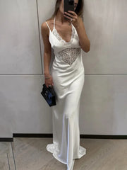 Woman in a white evening gown with lace detailing taking a mirror selfie.
