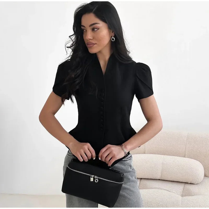 Woman holding a black handbag against a white background