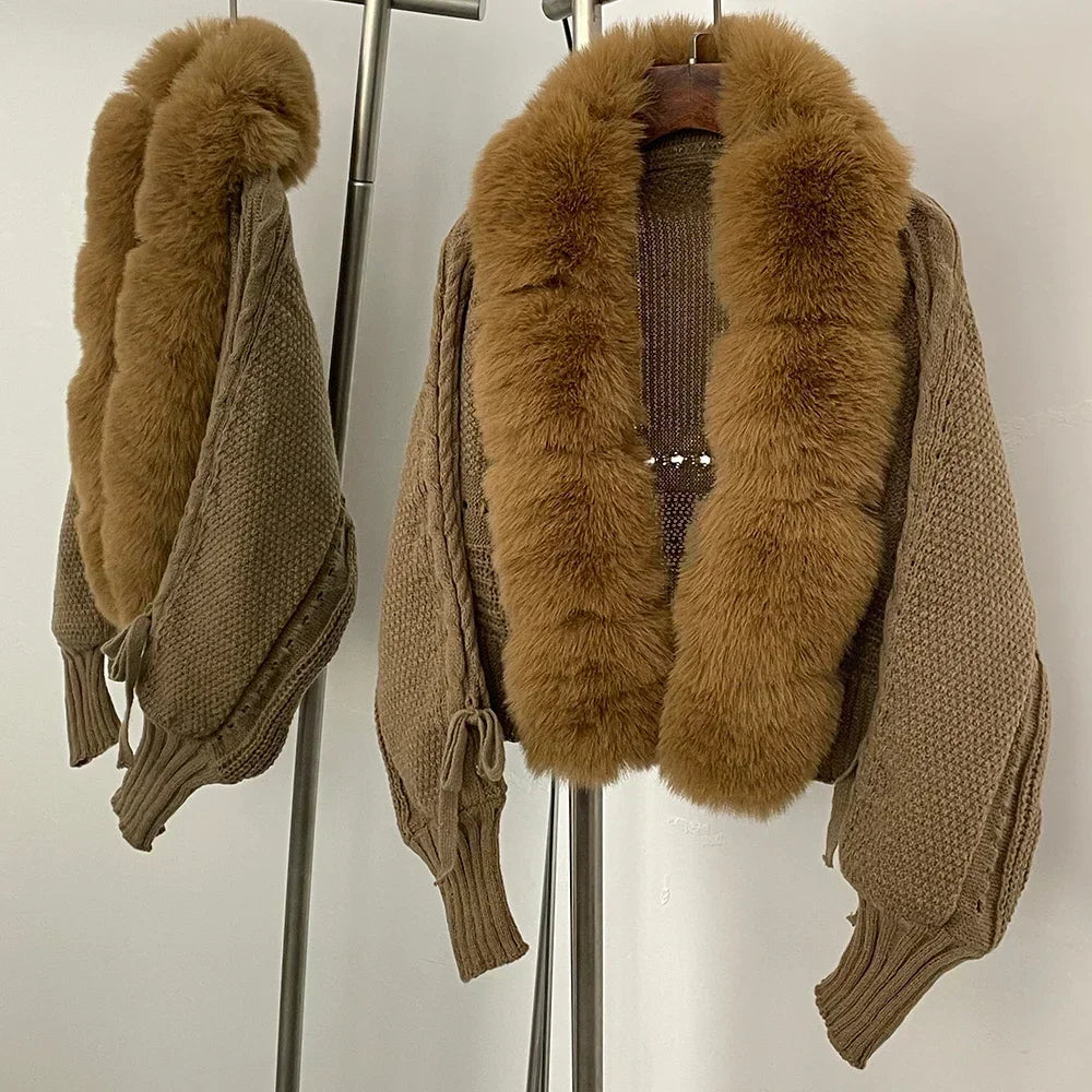 Brown knitted cardigan with fur collar on a hanger against a white background