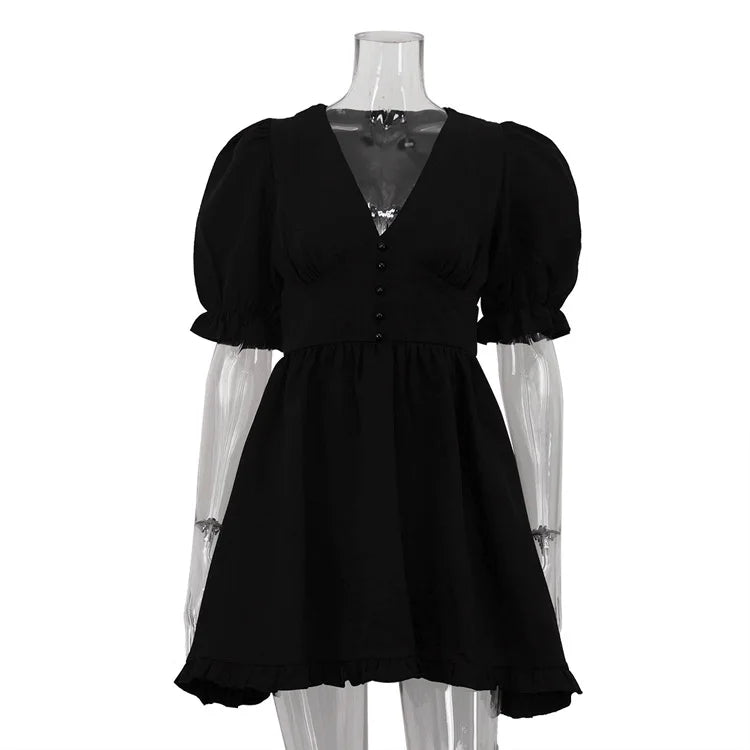 Black dress on a mannequin with sheer sleeves against a white background