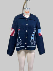 Mannequin displaying navy blue intarsia knit coat with sailboat pattern