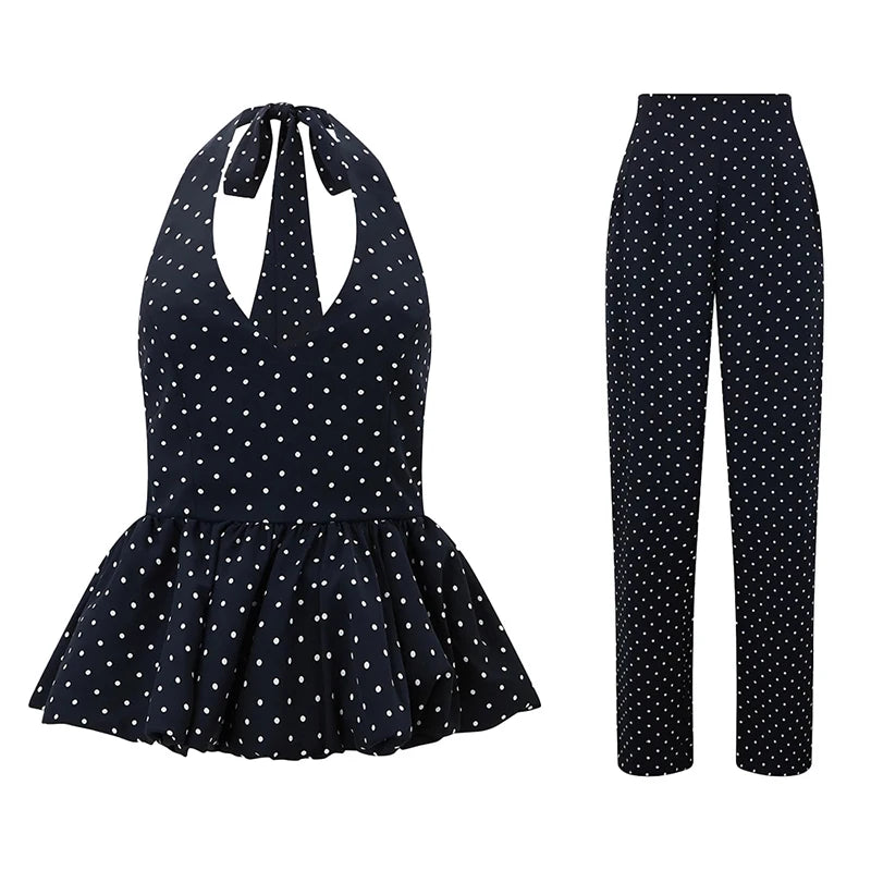 Navy polka dot jumpsuit with peplum top and flared pants on a white background