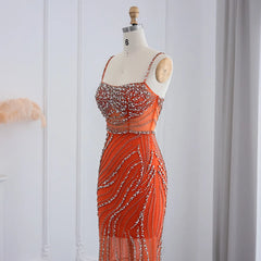 Mannequin  displaying the orange crystal mermaid evening gown, showcasing its flattering silhouette and flowing train. Golden Atelier 3