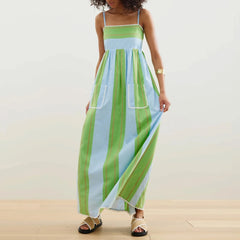 Woman wearing a green and blue striped dress on a plain background