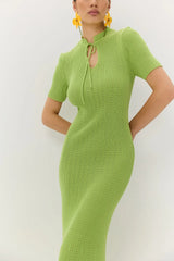 Woman wearing a green knitted dress against a white background