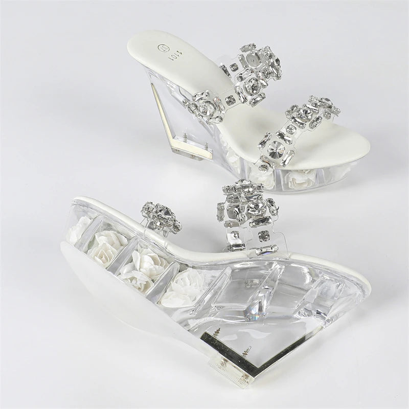 Clear high-heeled shoes with decorative crystals on a white background