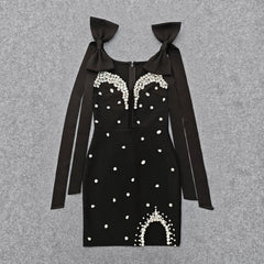 Black embellished bow strap mini dress laid flat