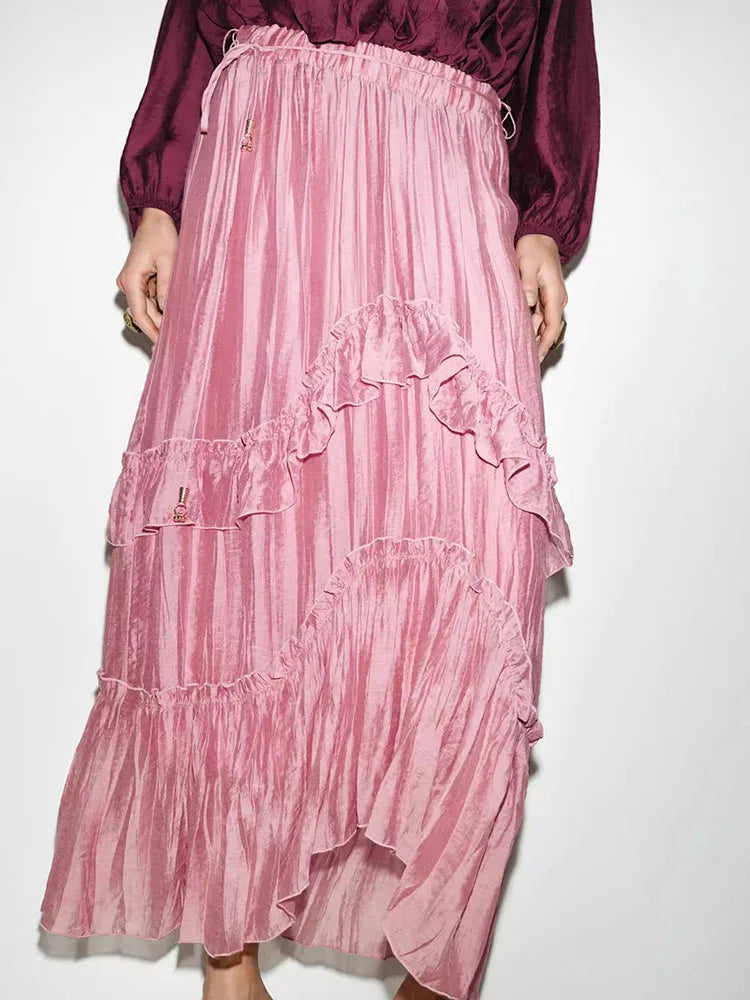 Close-up of the tiered ruffle detail on a pink maxi skirt.