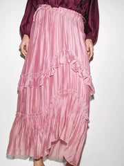 Close-up of the tiered ruffle detail on a pink maxi skirt.