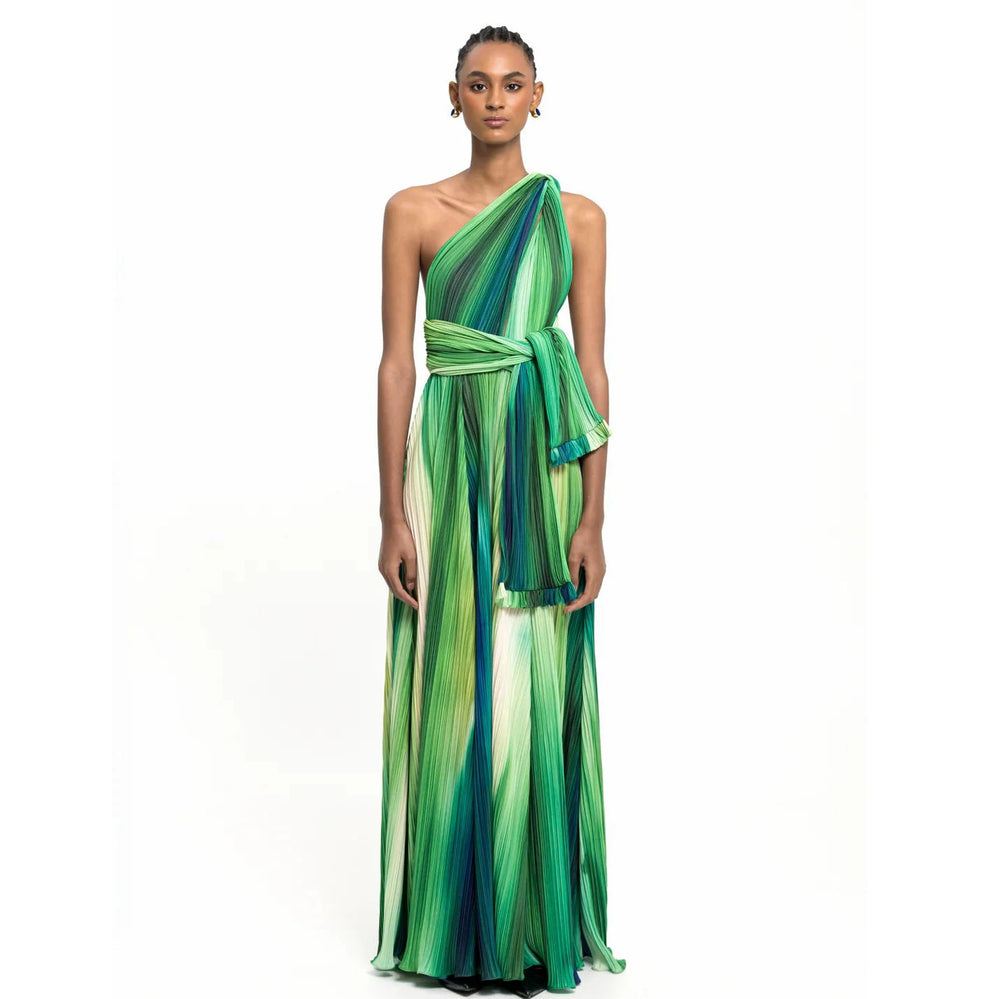 Woman wearing a one-shoulder pleated maxi skirt and bodysuit set with an abstract print.