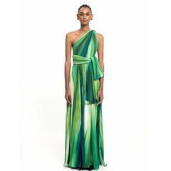 Woman wearing a one-shoulder pleated maxi skirt and bodysuit set with an abstract print.