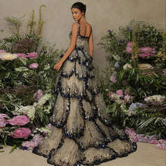 A model wearing a shimmering sequin butterfly layered gown with a flowing silhouette, perfect for special occasions. 9