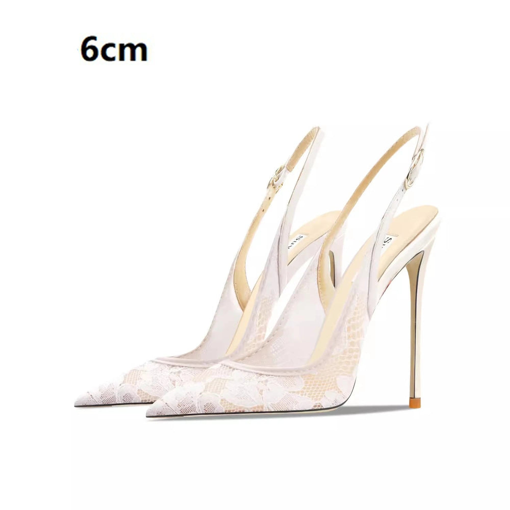 White high-heeled shoes with gold accents on a white background