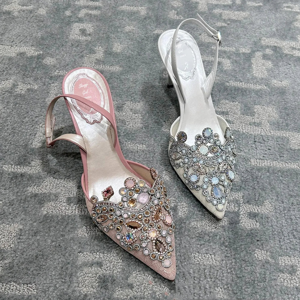 Pair of embellished high-heeled shoes on a textured surface