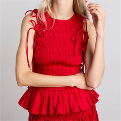 Woman wearing red ruffled smocked crop top with puff sleeves and fitted waist