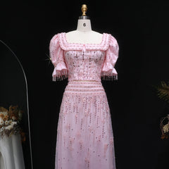 Pink dress with floral embellishments on a mannequin against a black background