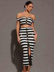 Woman wearing a black and white striped outfit with button details on a gray background