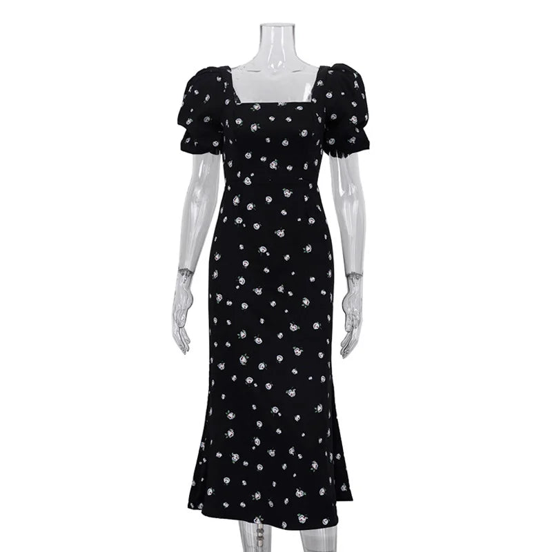 Black dress with white floral pattern on a mannequin against a white background